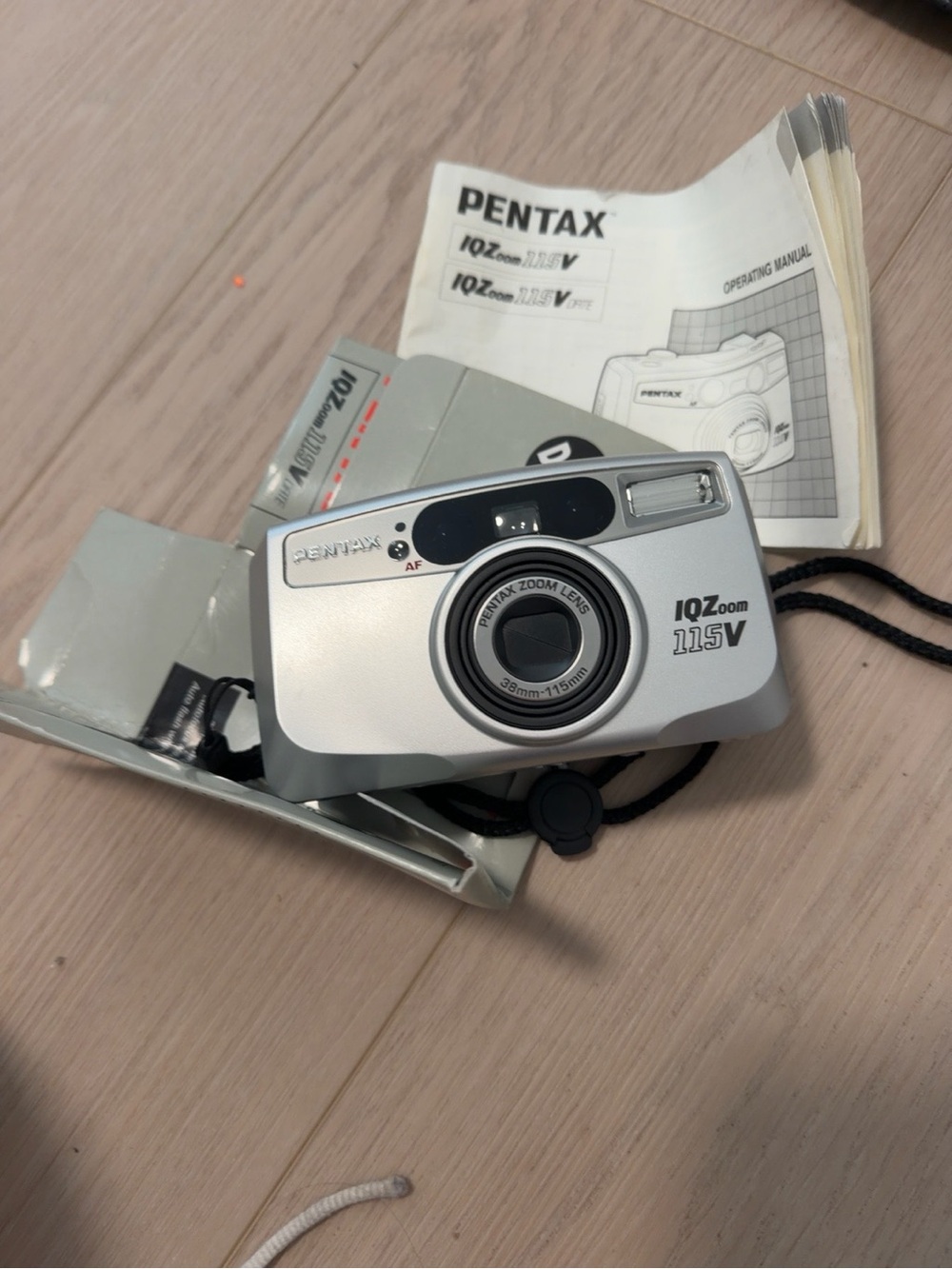 Pentax silver compact film camera with wrist strap